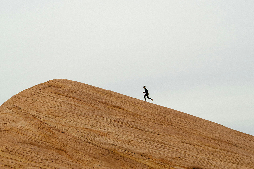 A lone runner climbing up a hill, indicating now ascending difficulty increases manager participation