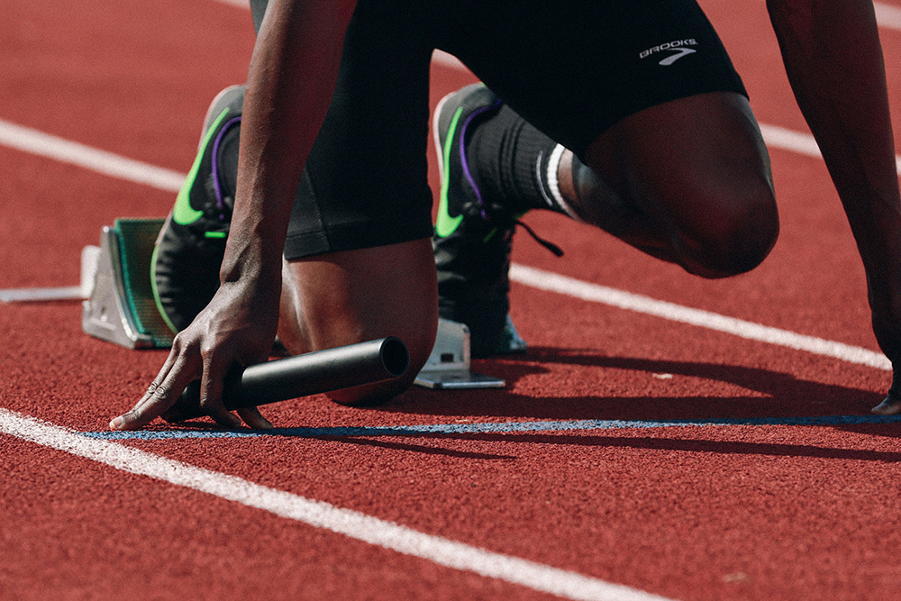 Athlete in relay race in a starting position, giving off a vibe of competence, the feeling of which can increase manager participation