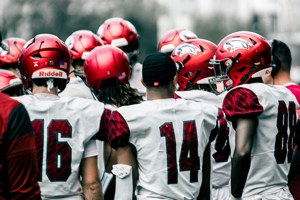 A team of American football players wearing matching jerseys and helmets, indicating the importance of belonging to a team to manager participation in LDPs
