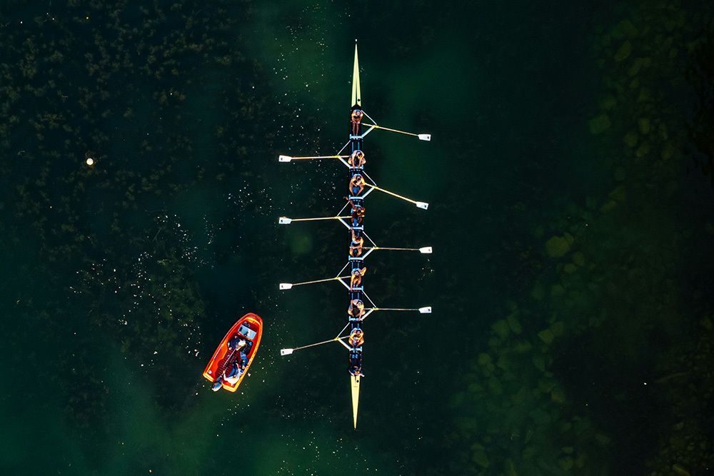 Top view of a team of rowers in a boat, denoting increasing motivation connectedness